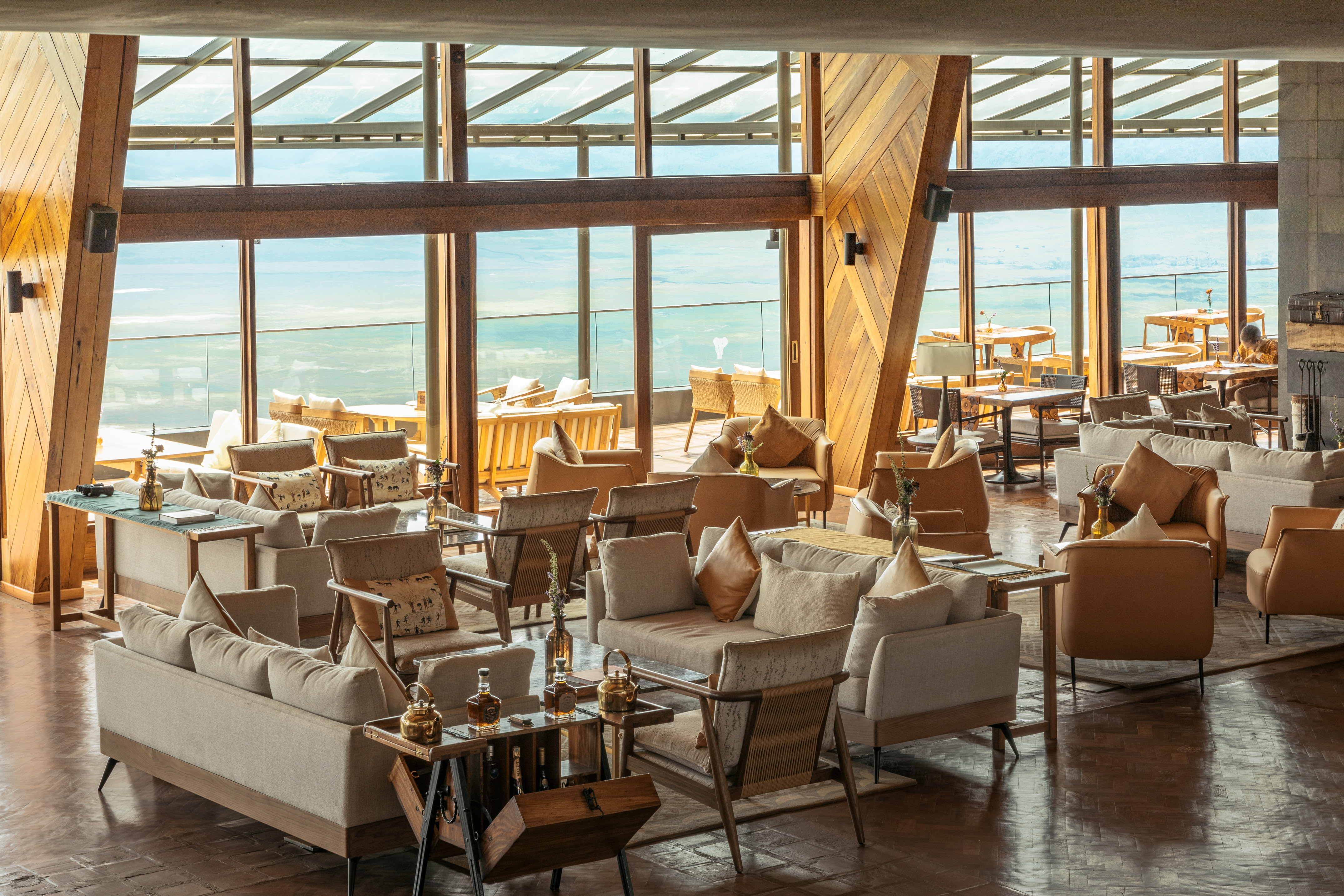 Safari lodge lounge with panoramic views, comfortable seating, and wood design.