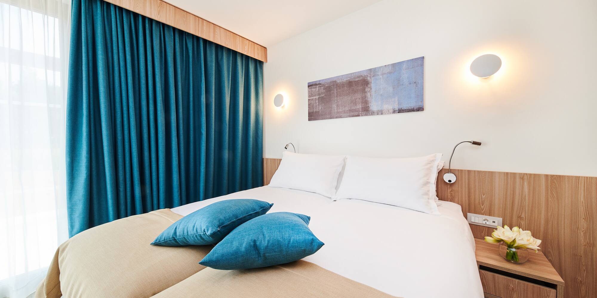 a bed with blue pillows and a blue curtain