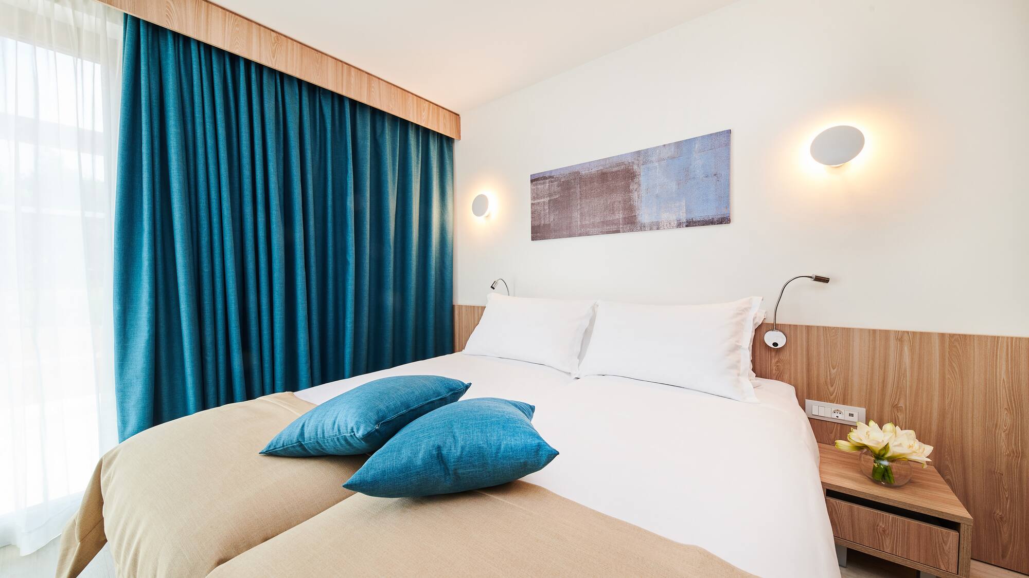 a bed with blue pillows and a blue curtain