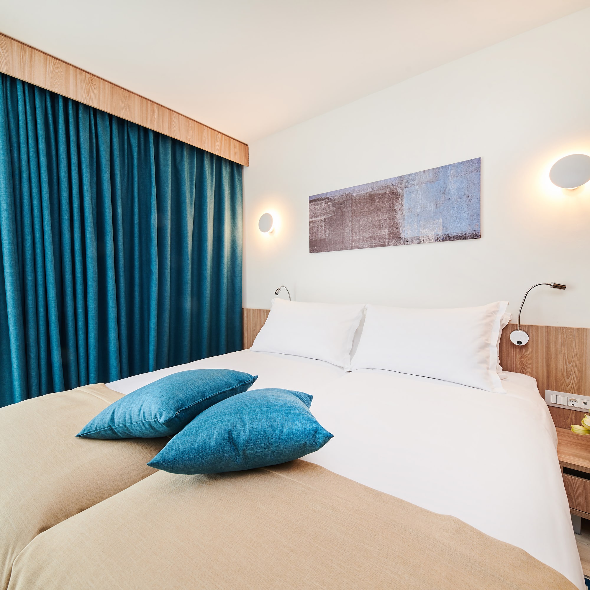 a bed with blue pillows and a blue curtain