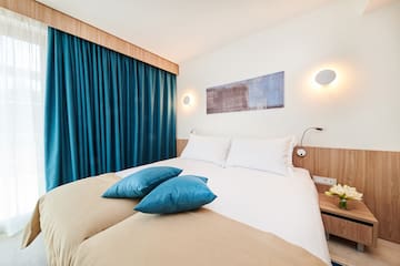 a bed with blue pillows and a blue curtain