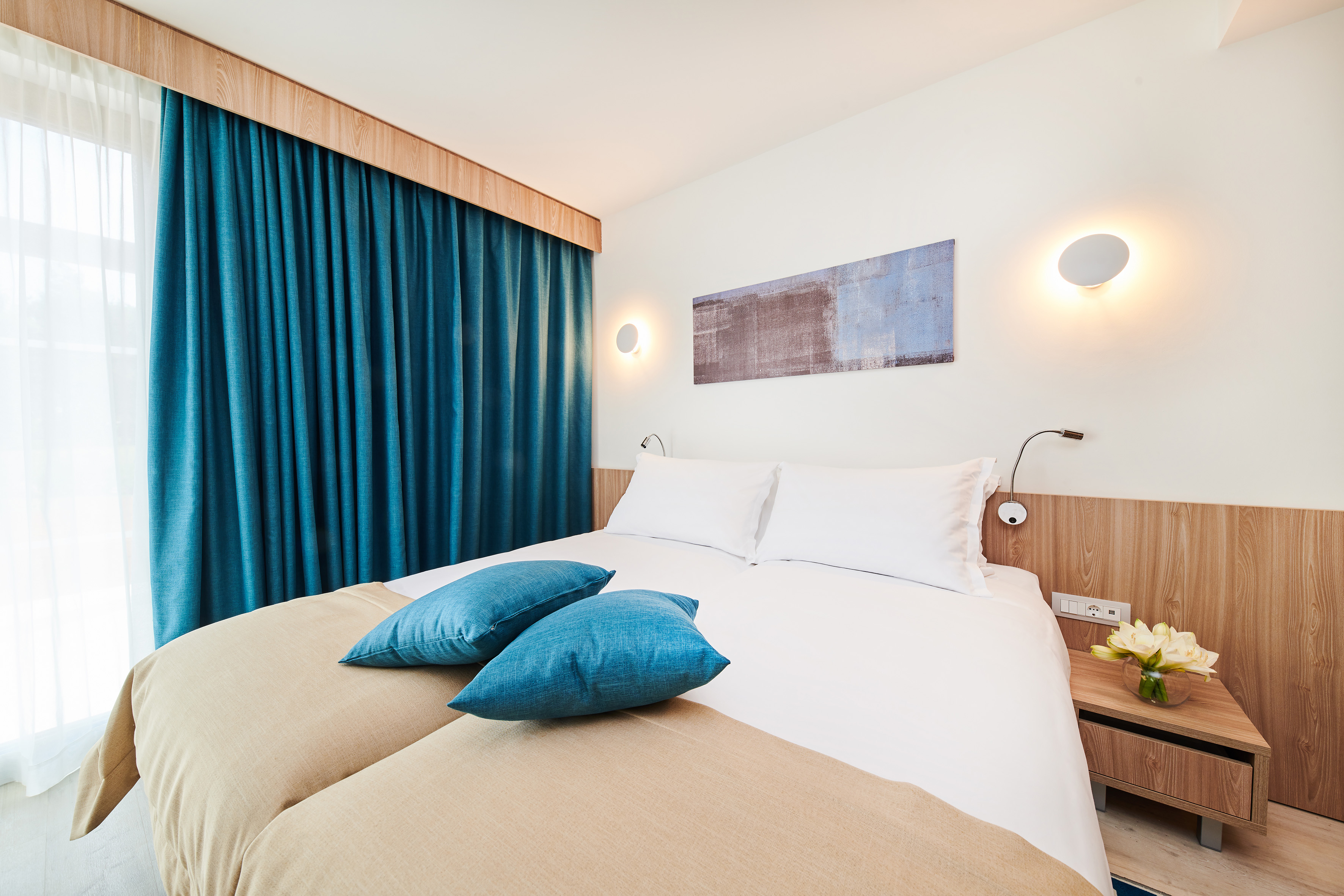 a bed with blue pillows and a blue curtain