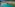 Turquoise mountain lake beside an alpine village with rugged peaks.