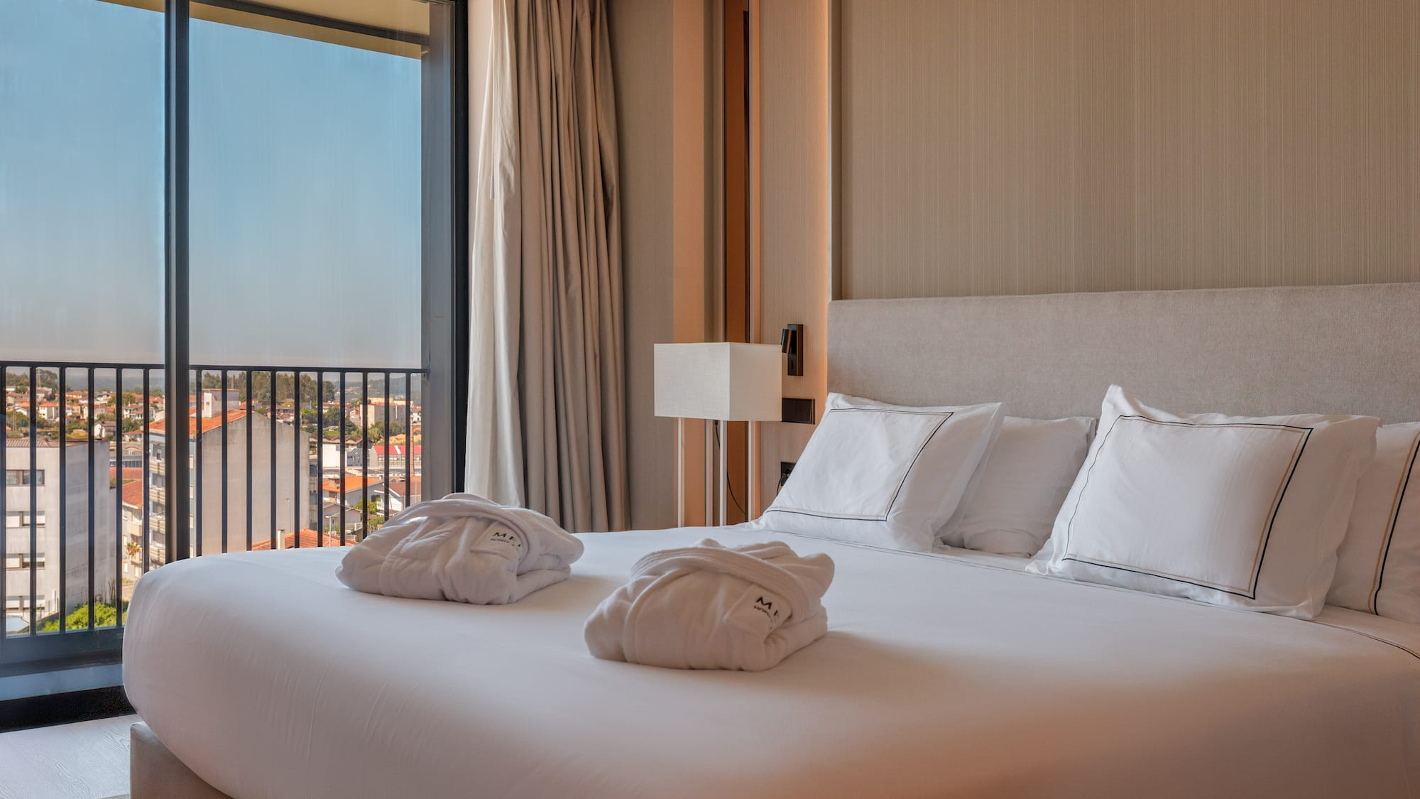 a bed with white sheets and towels on it