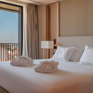 a bed with white sheets and towels on it