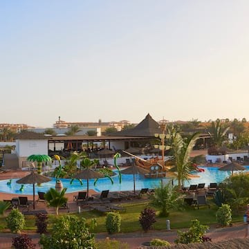 a pool with lounge chairs and umbrellas in a resort