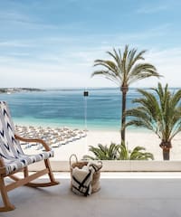 a chair on a balcony overlooking a beach
