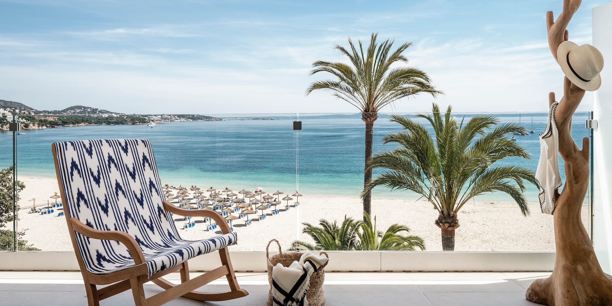 a chair on a balcony overlooking a beach