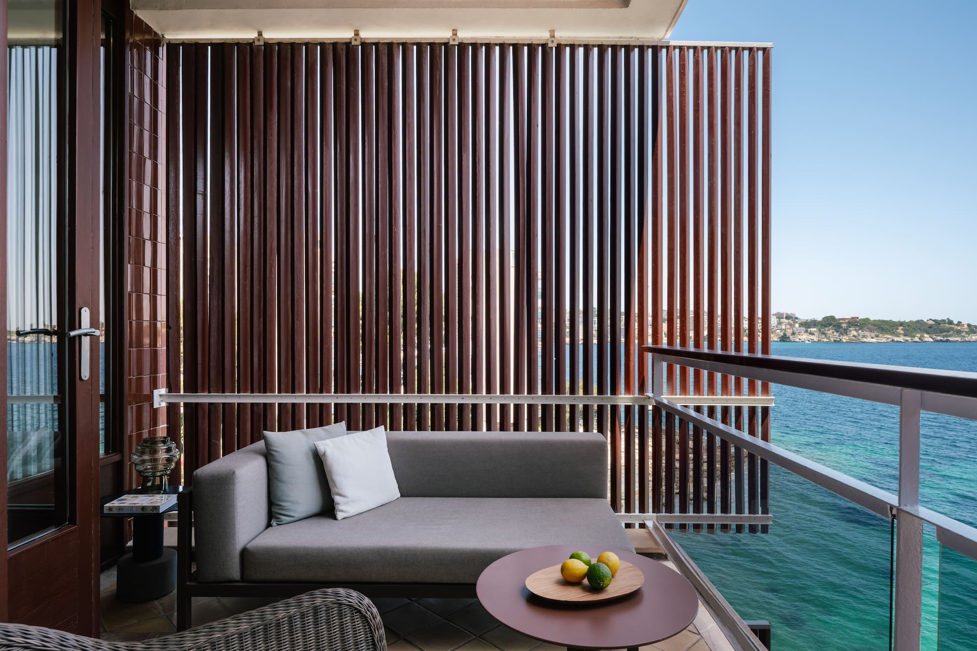 a couch and a table on a balcony overlooking water