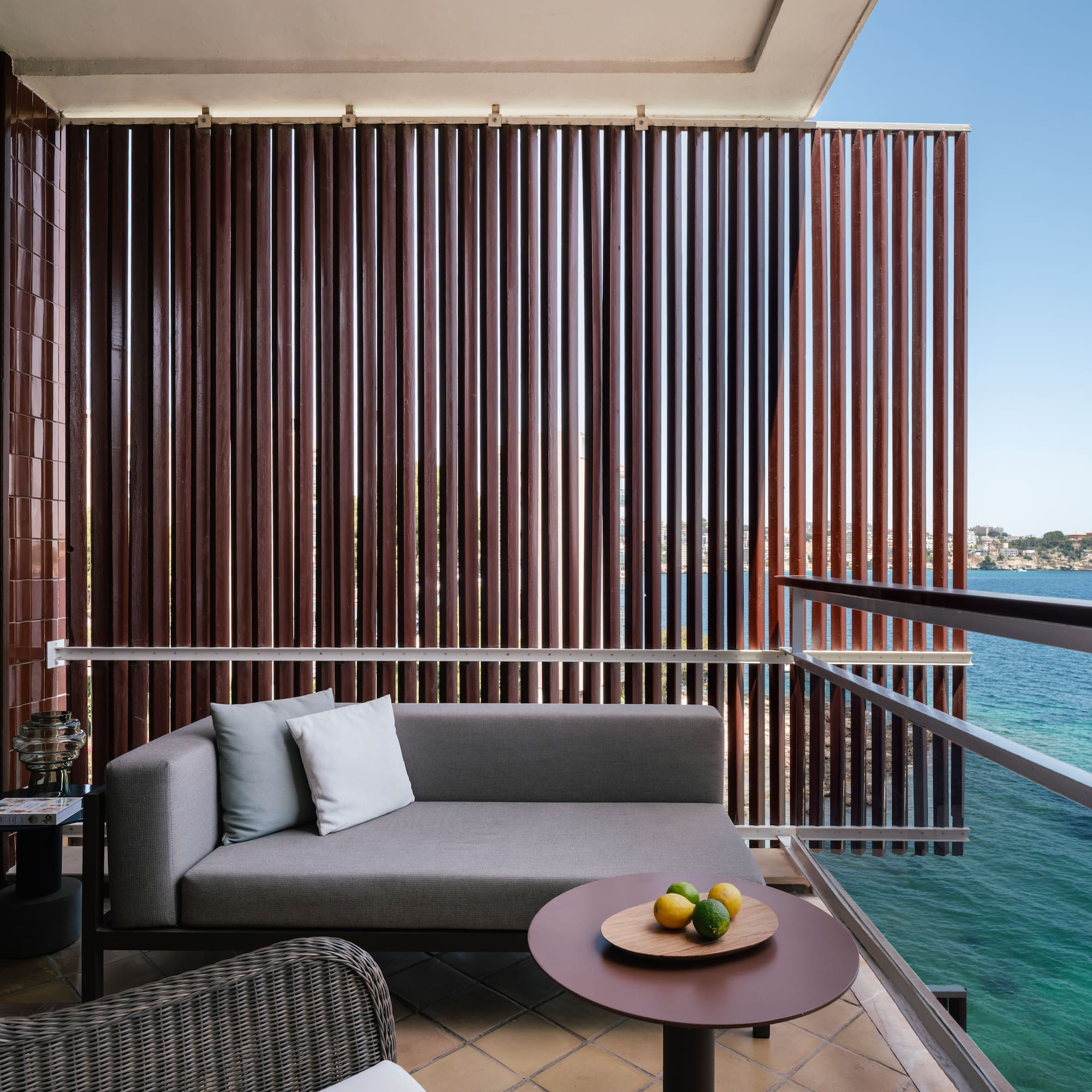 a couch and a table on a balcony overlooking water
