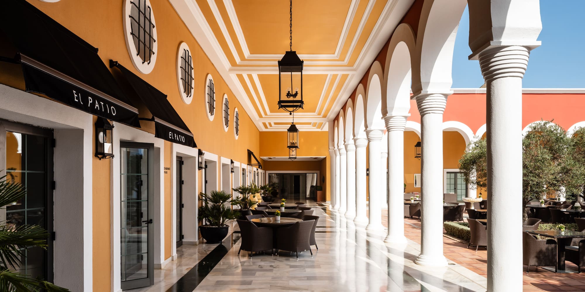 a building with a yellow wall and white columns