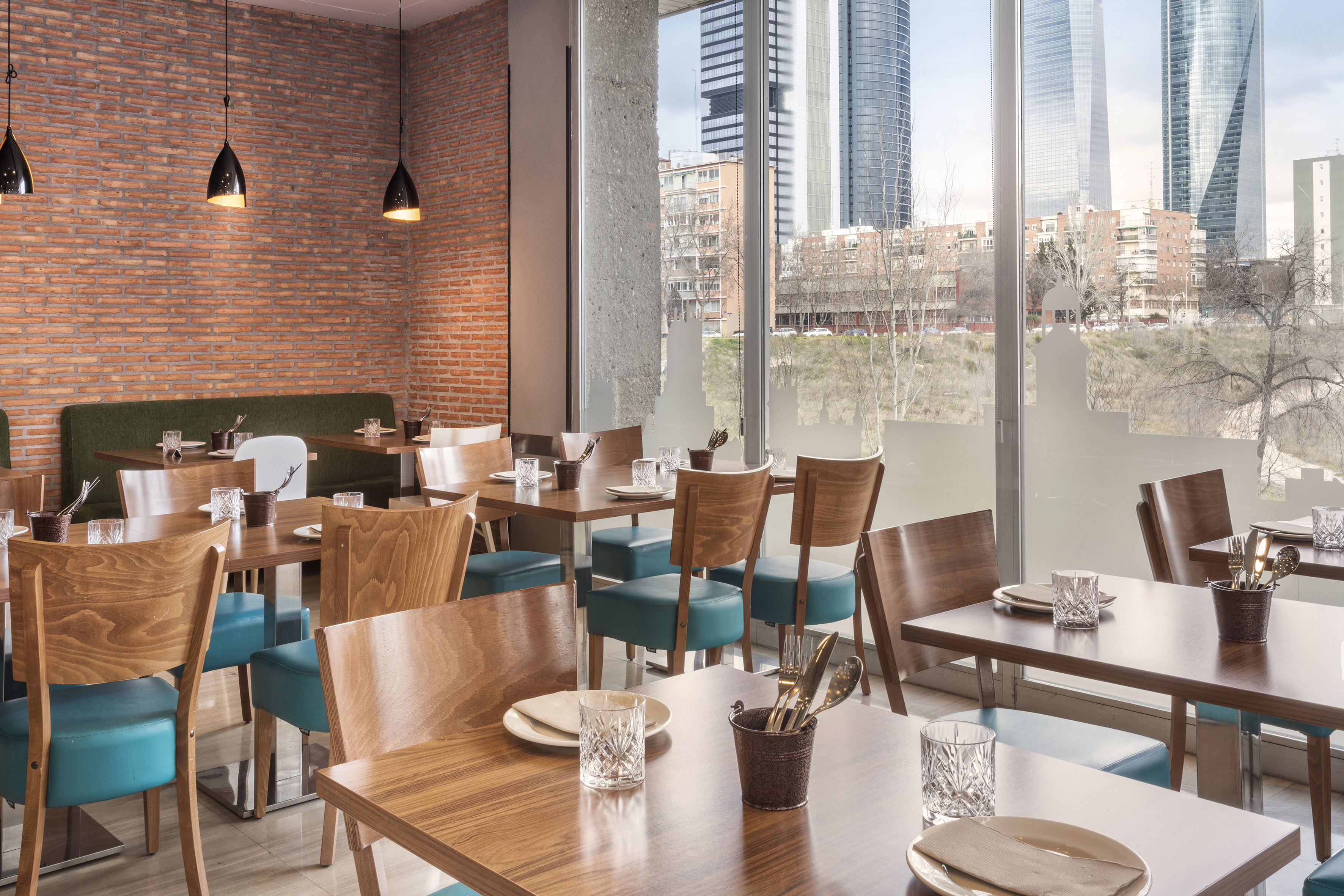 Modern restaurant interior, city skyline view, wooden tables, teal chairs.