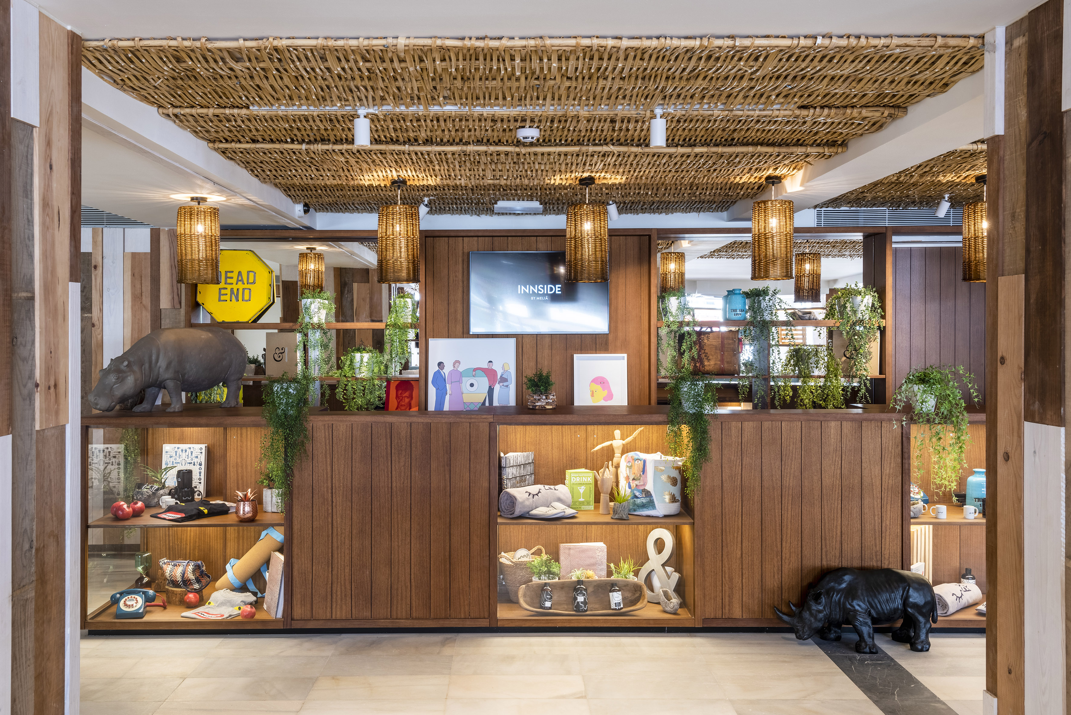 Modern INNSIDE by Meliá hotel lobby with eclectic display shelves and woven ceiling.