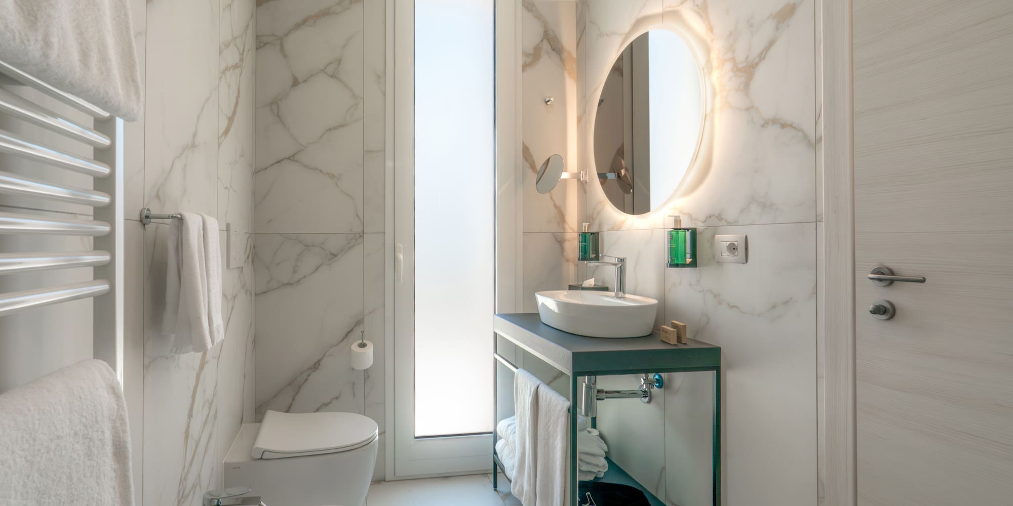 a bathroom with marble walls and a sink and toilet