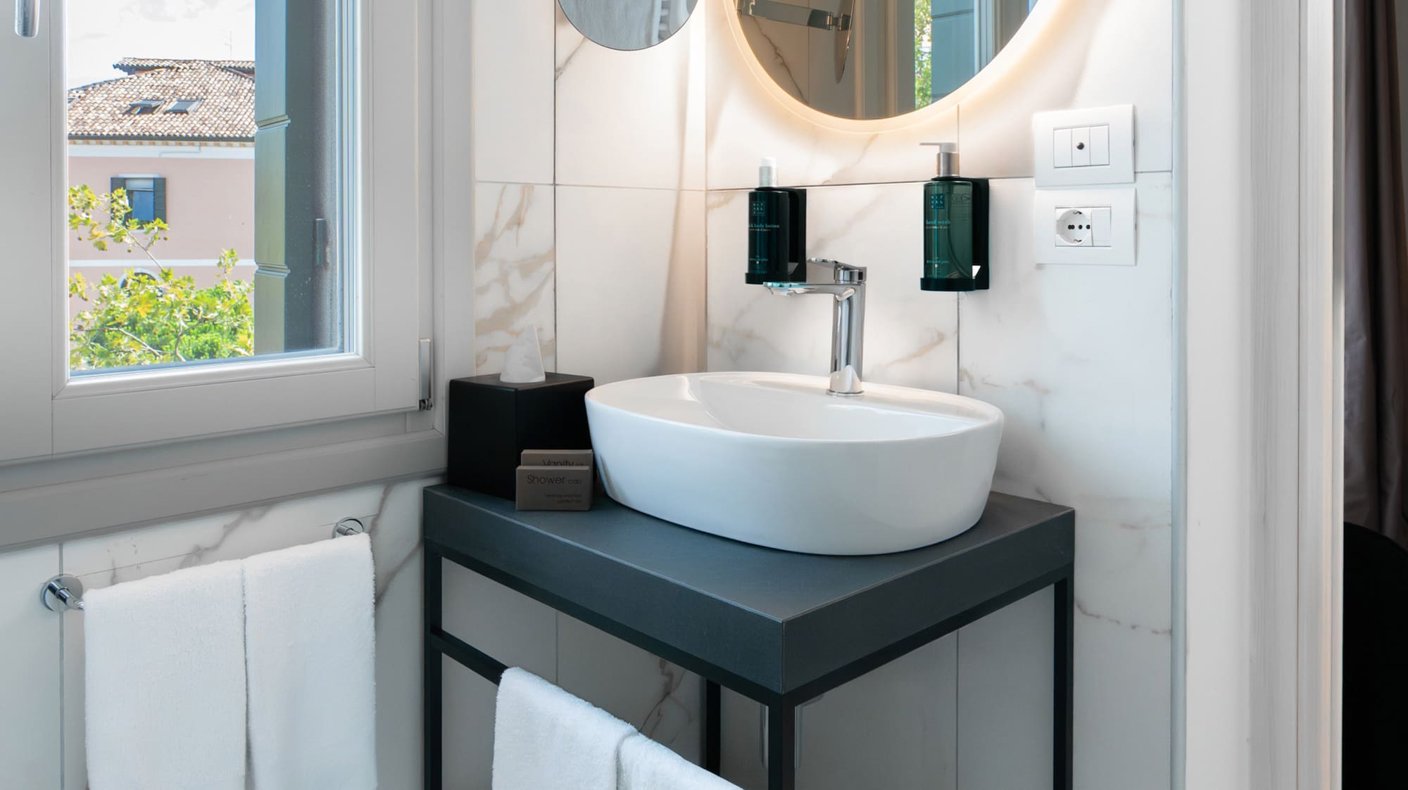 a bathroom with a round mirror and a sink