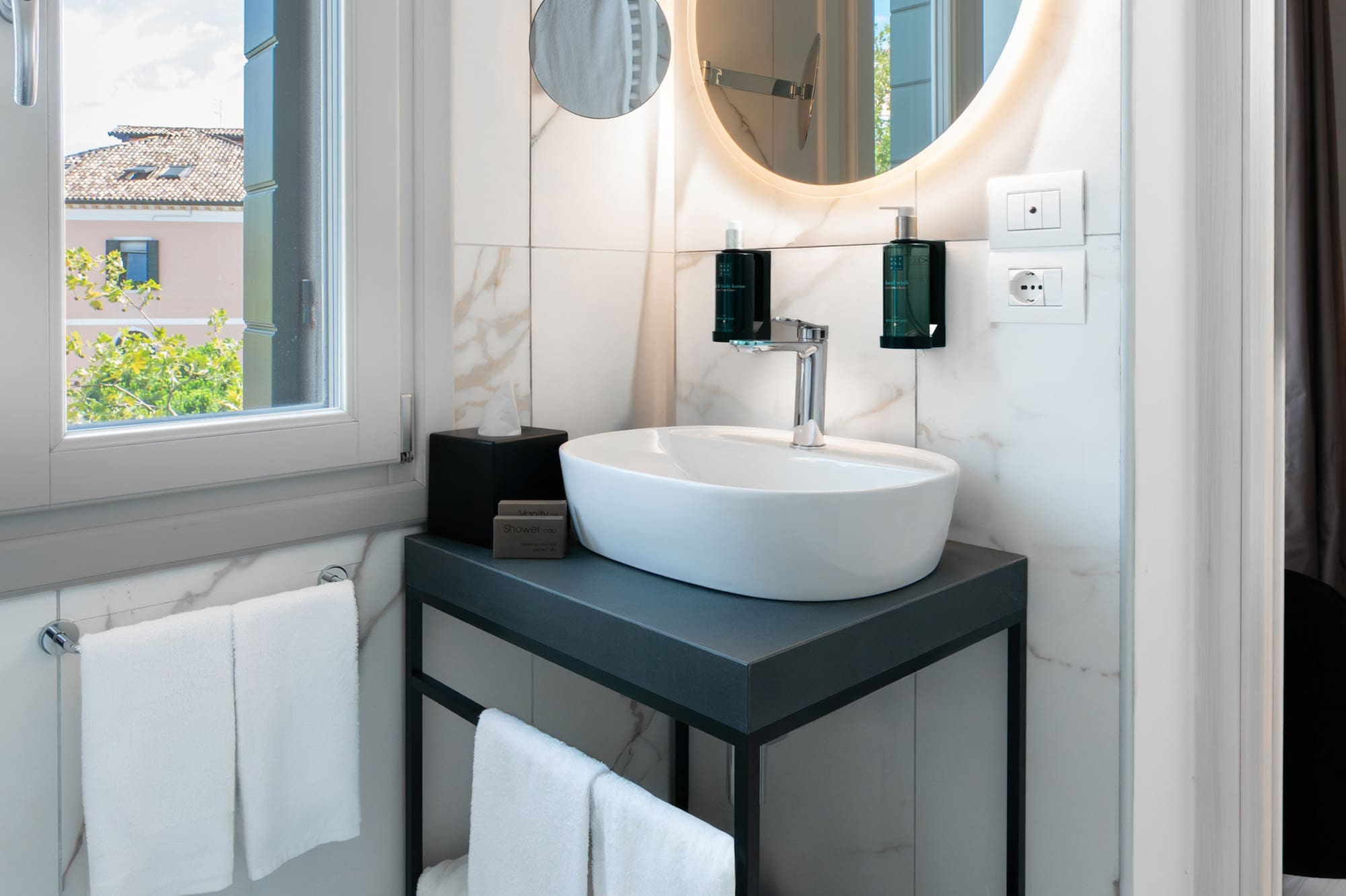 a bathroom with a round mirror and a sink