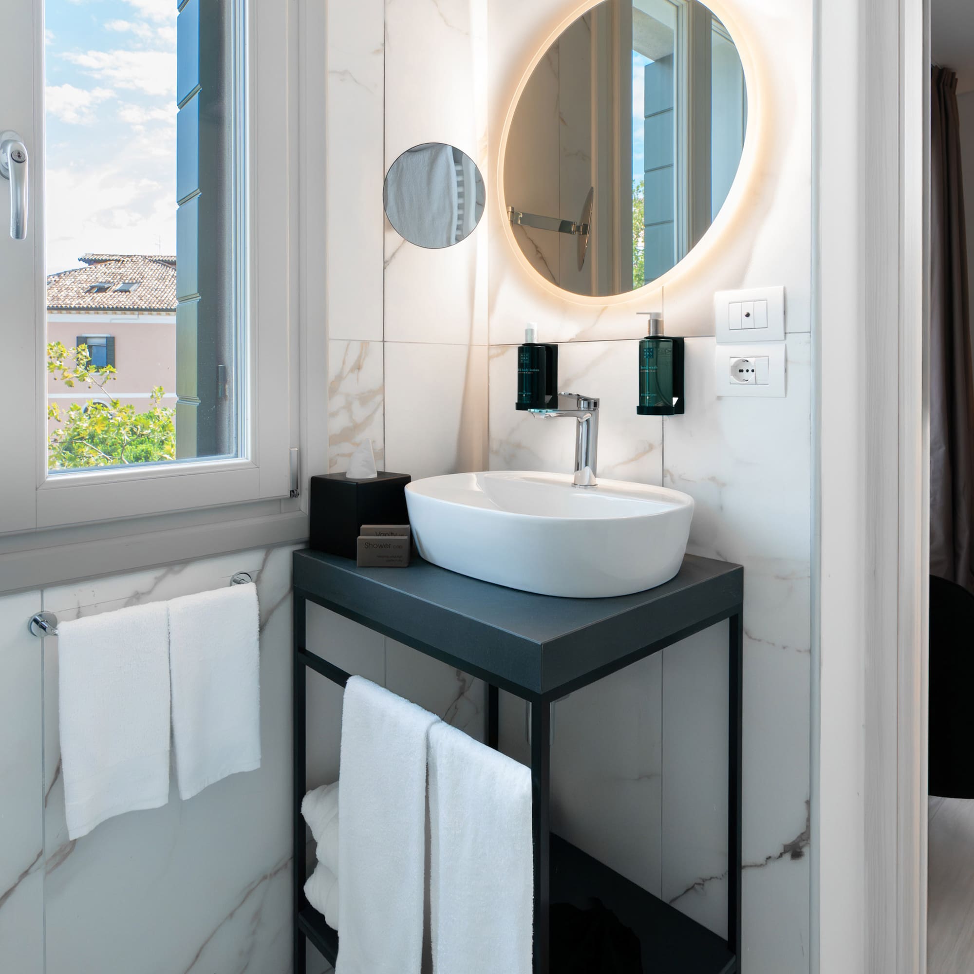 a bathroom with a round mirror and a sink