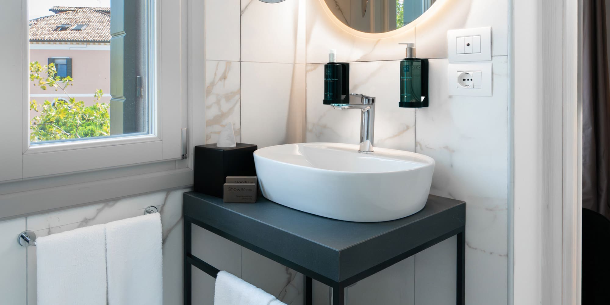 a bathroom with a round mirror and a sink