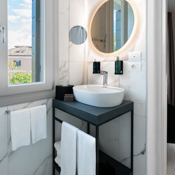 a bathroom with a round mirror and a sink