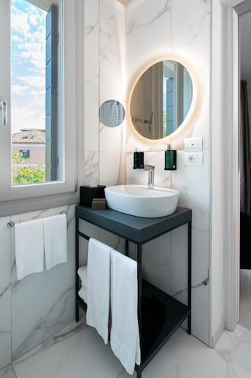a bathroom with a round mirror and a sink