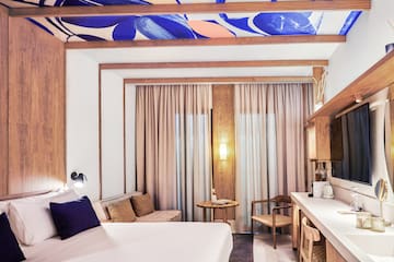 a room with a bed and a table and chairs