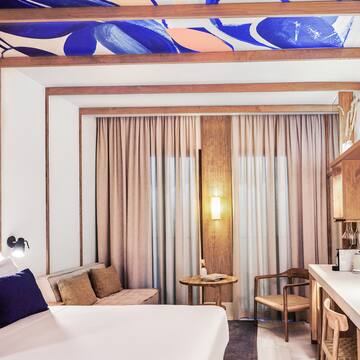 a room with a bed and a table and chairs