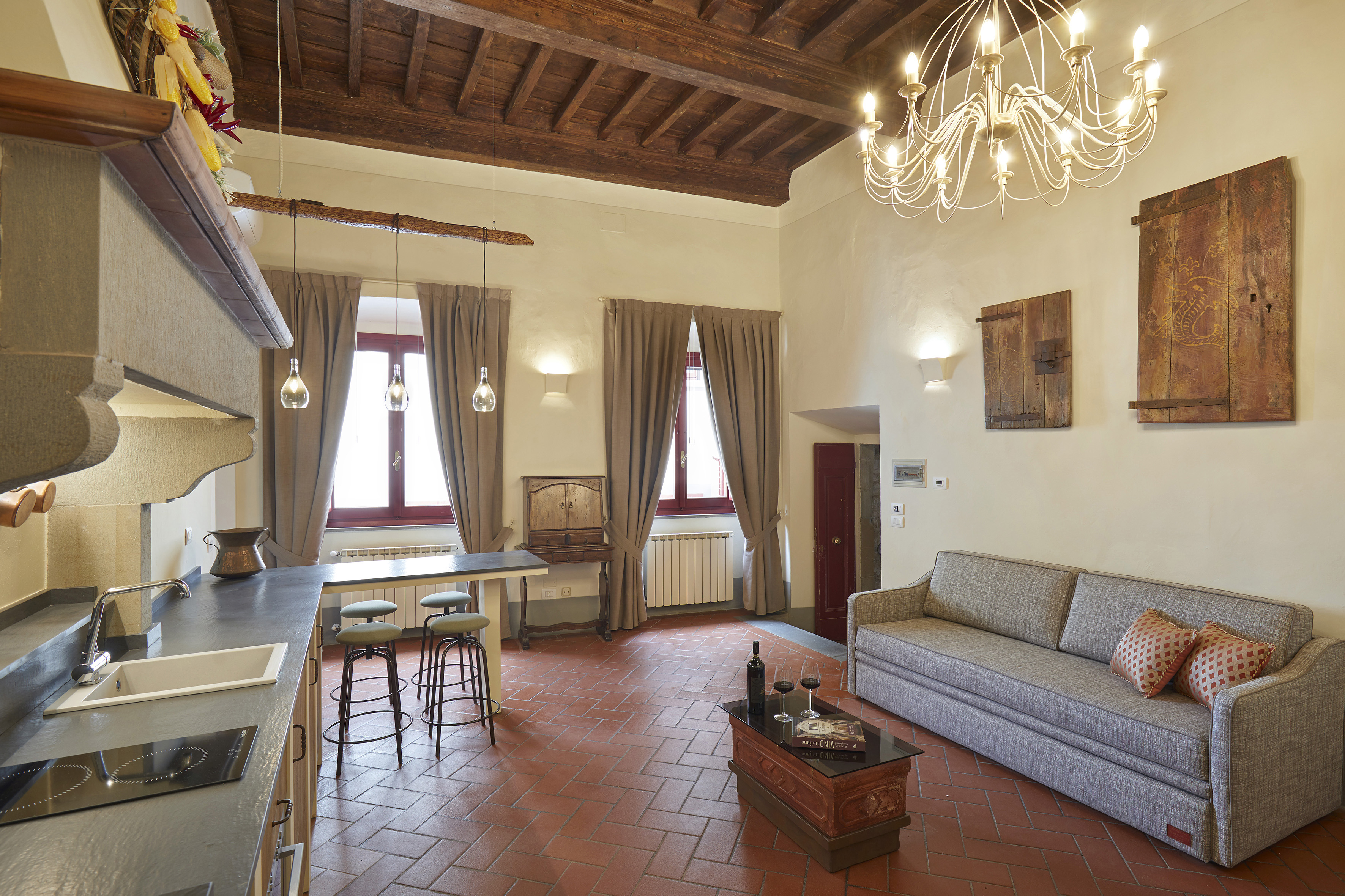 Elegant open concept kitchen living room, terracotta floor, wooden beams.