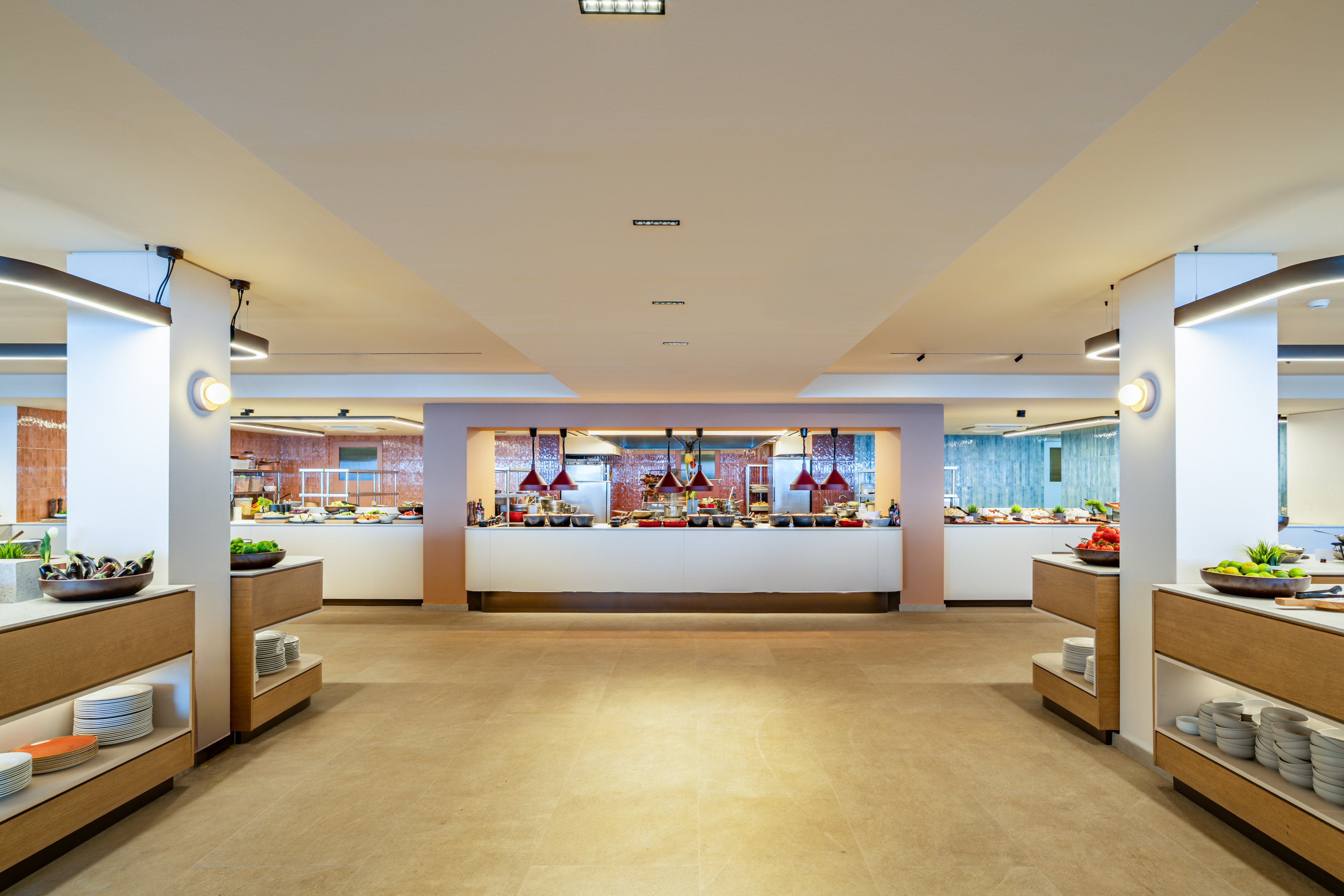 Modern hotel buffet setup with various food stations and fresh ingredients.