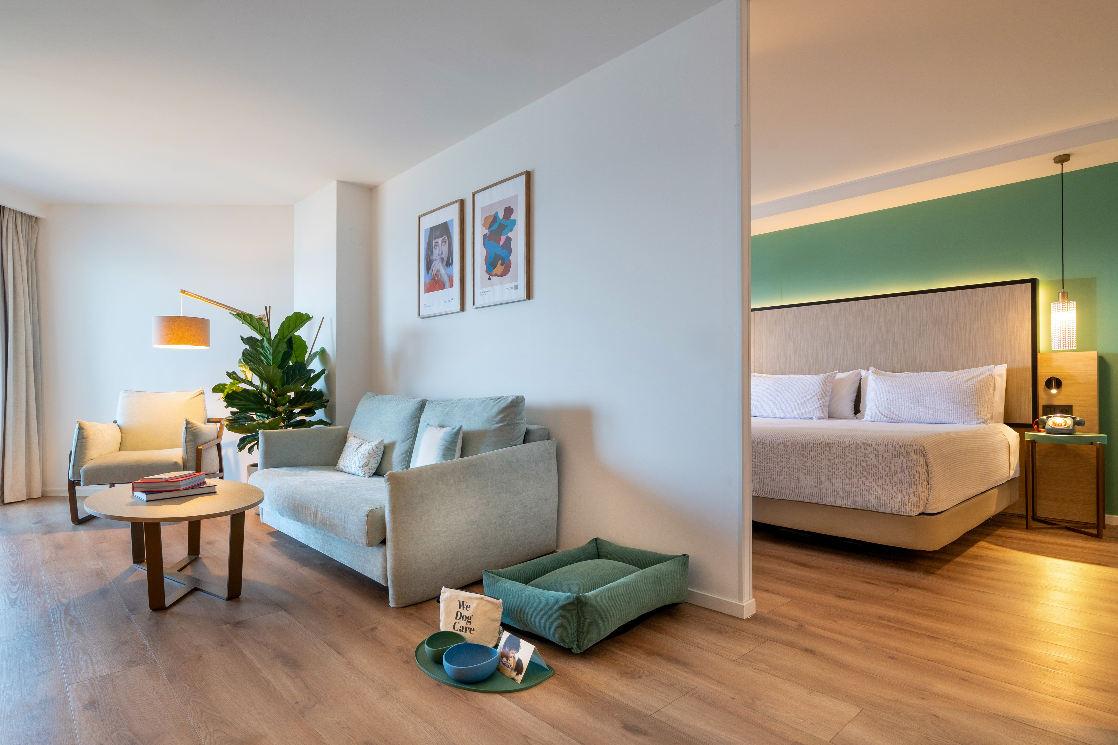 Pet-friendly hotel suite with living space, bedroom, dog bed, and bowls.