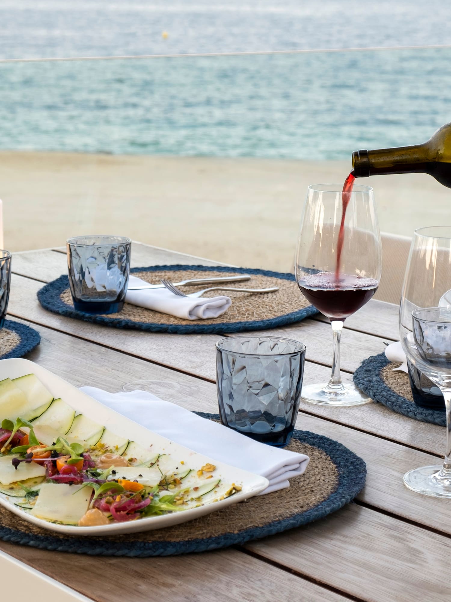 a wine being poured into a glass on a table