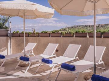 a group of chairs and umbrellas on a patio