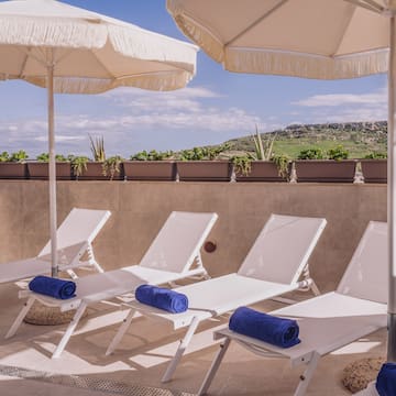 a group of chairs and umbrellas on a patio