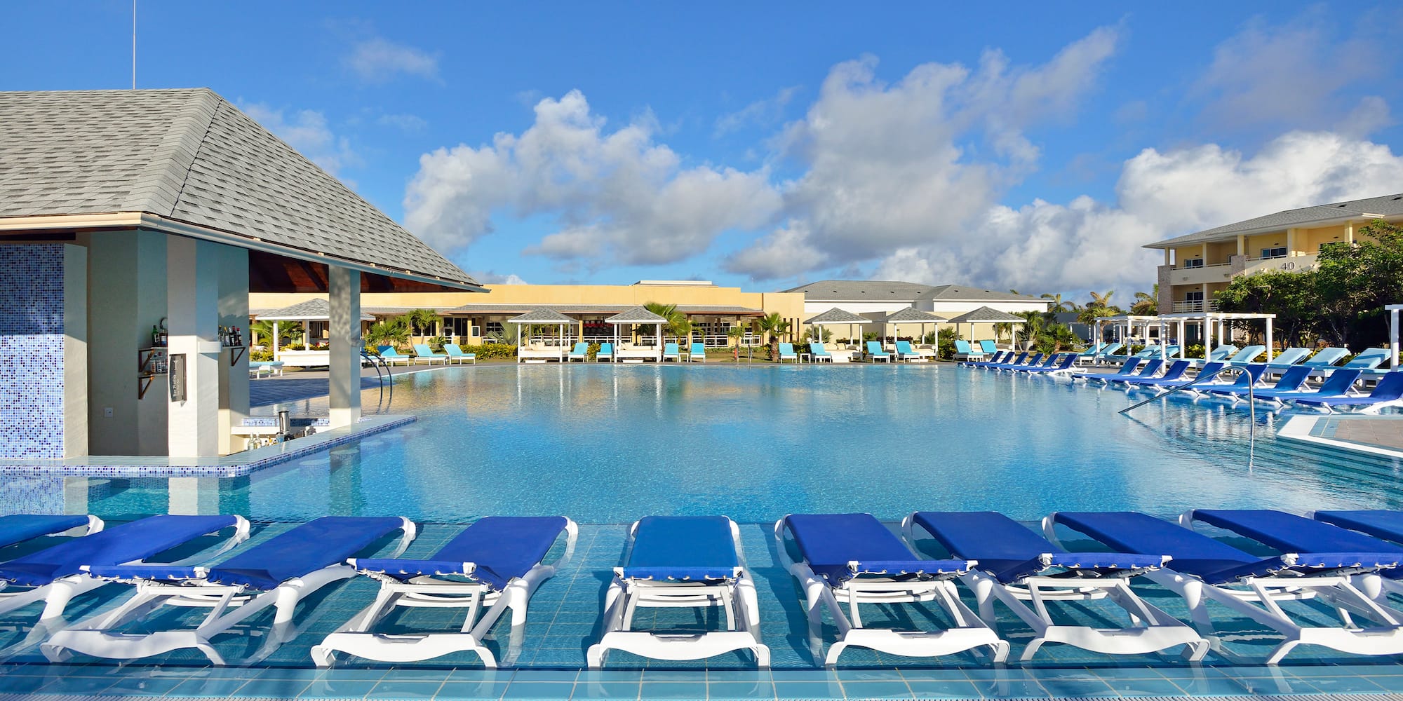 a pool with lounge chairs and a building