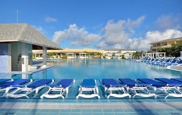 a pool with lounge chairs and a building
