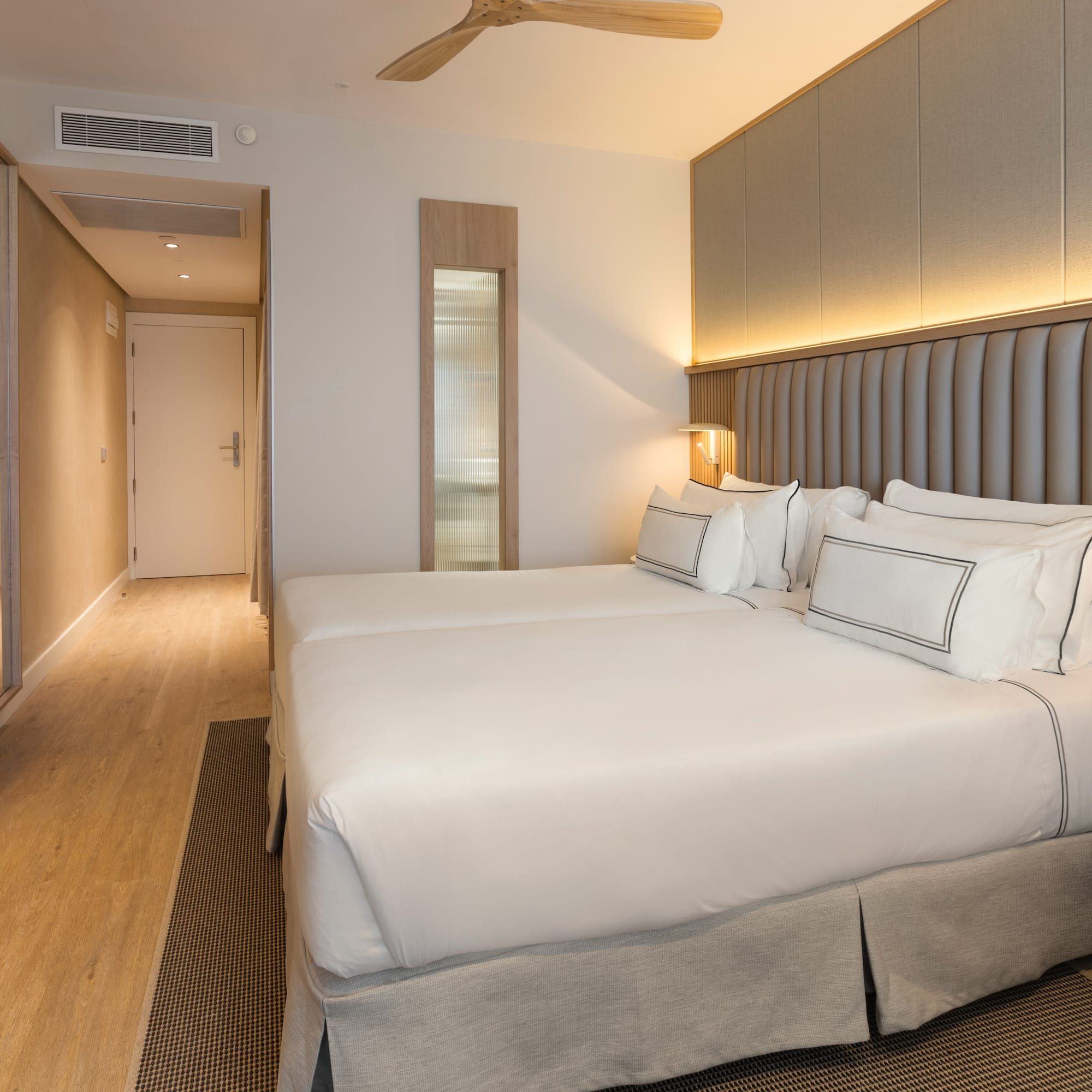 a room with two beds and a ceiling fan