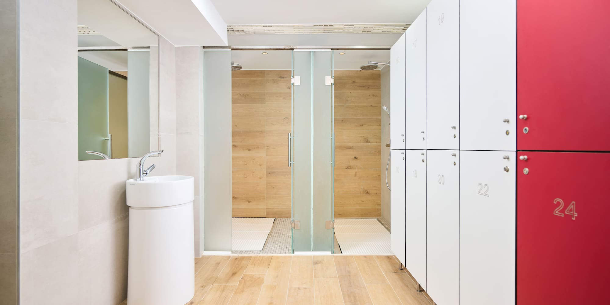 a bathroom with white lockers and a shower