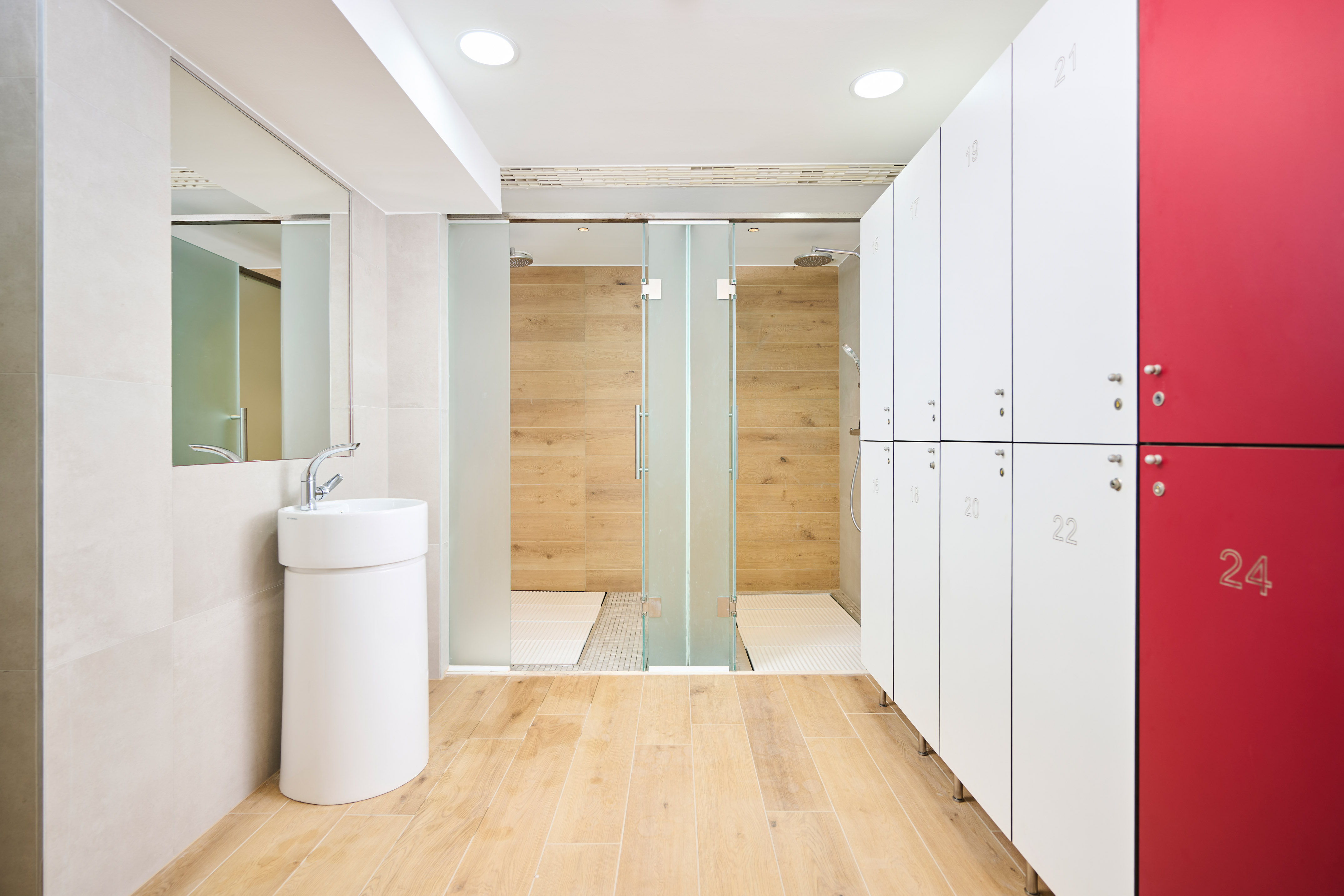 a bathroom with white lockers and a shower