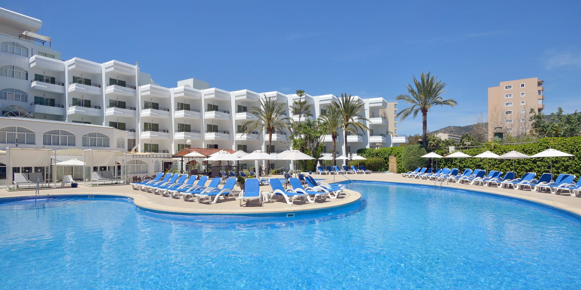 a pool with lounge chairs and umbrellas