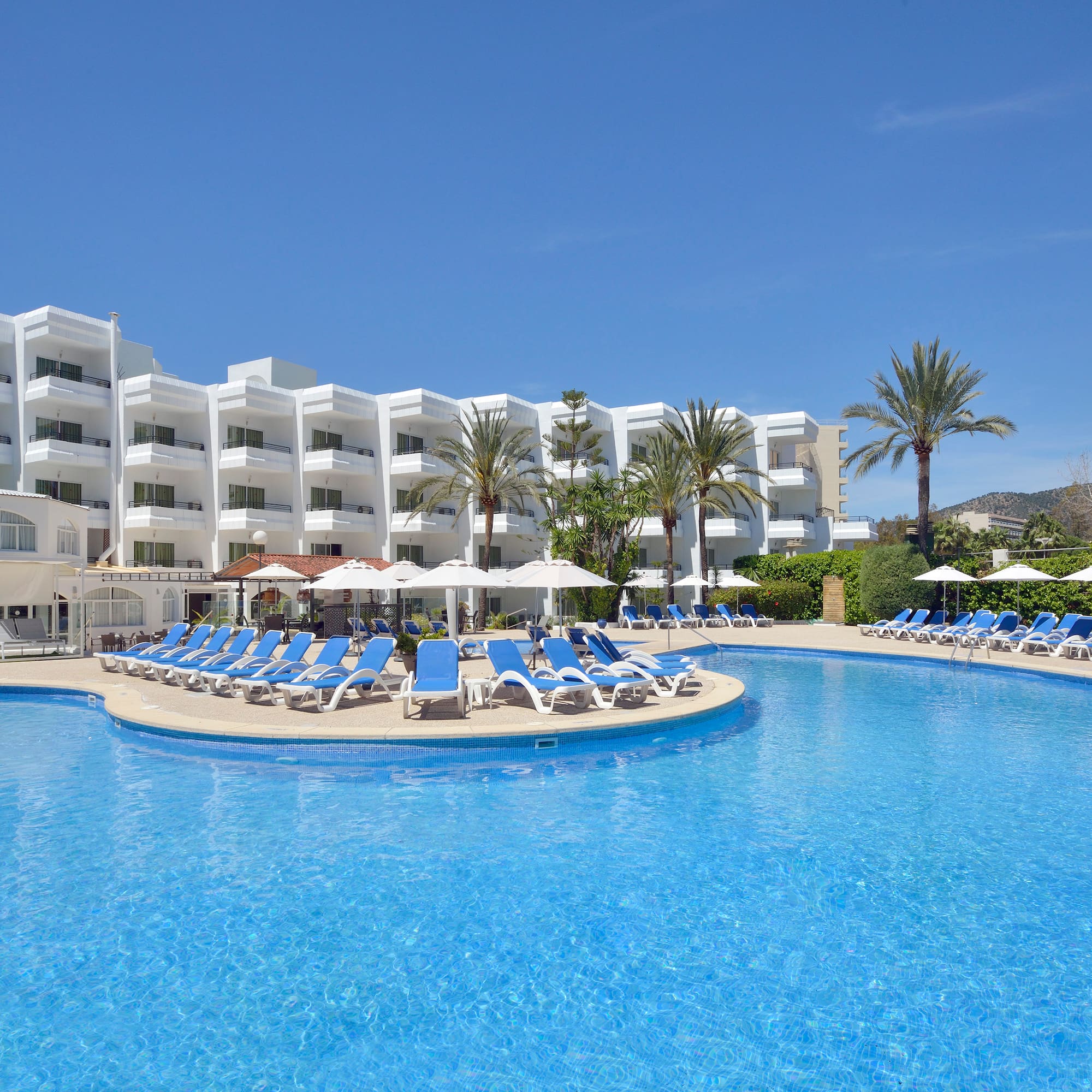 a pool with lounge chairs and umbrellas