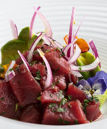 a plate of raw meat with vegetables
