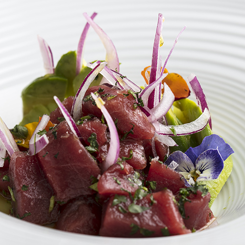 a plate of raw meat with vegetables