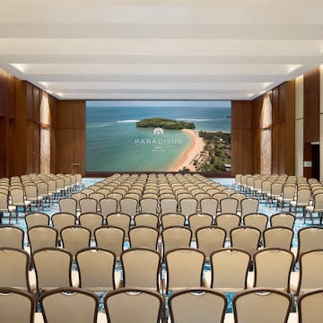 a large room with chairs and a screen