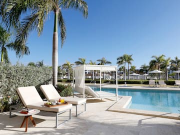 a pool with lounge chairs and palm trees