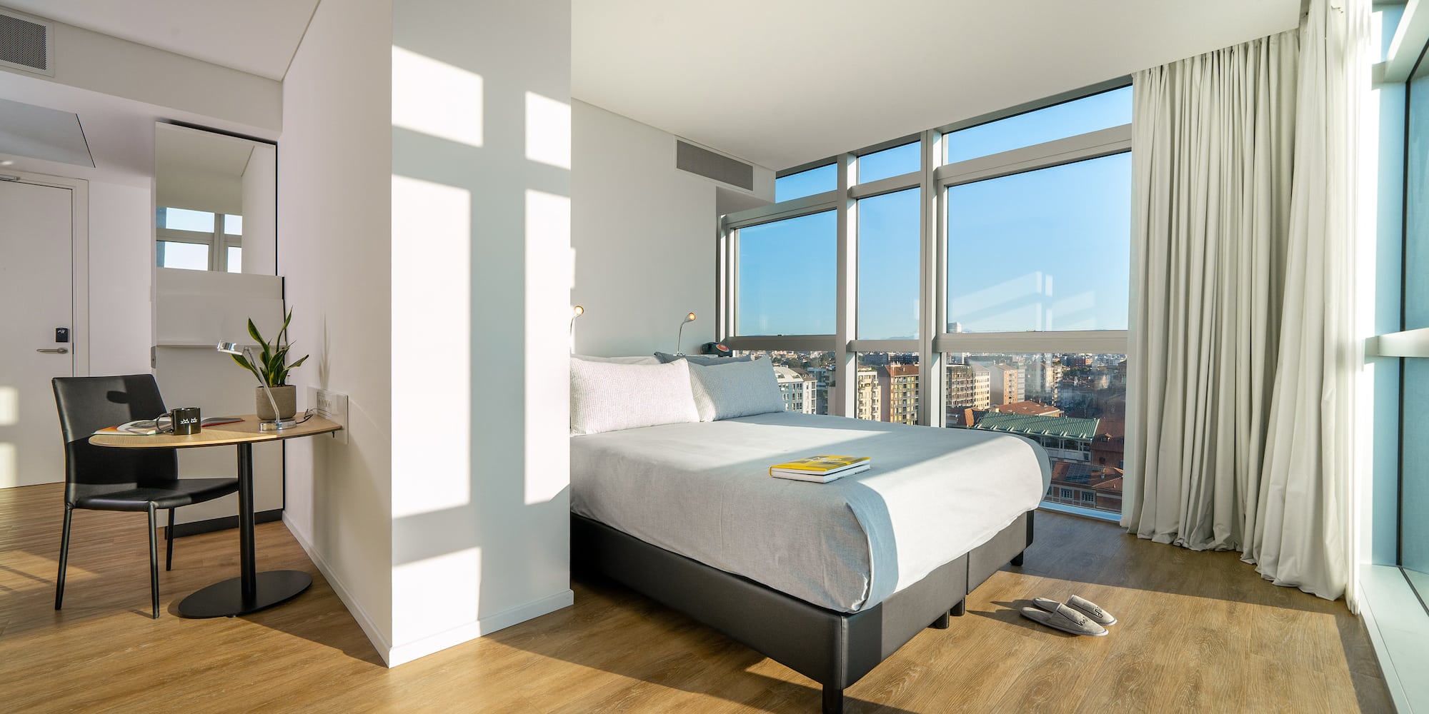 a bedroom with a large window and a bed