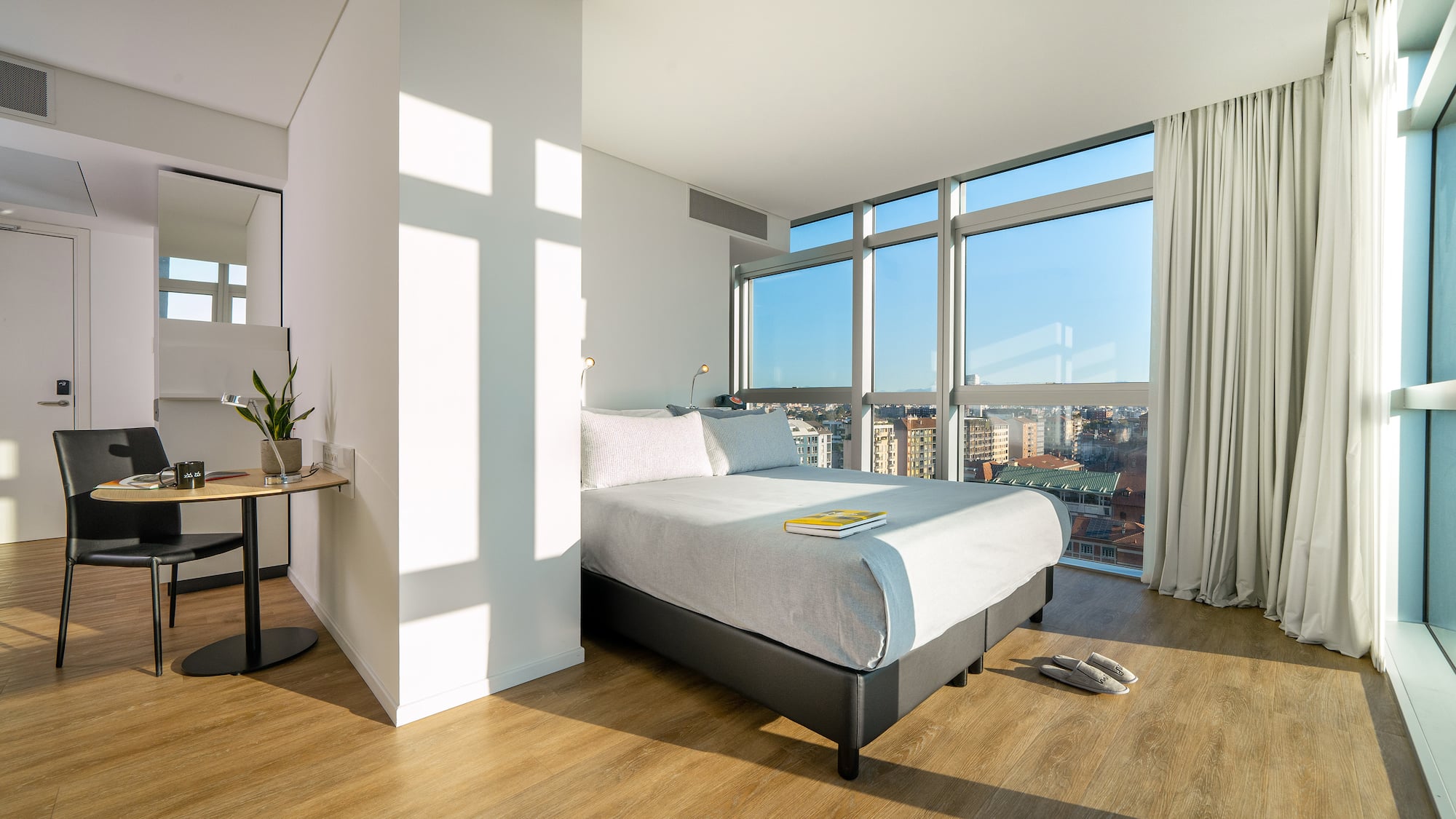 a bedroom with a large window and a bed