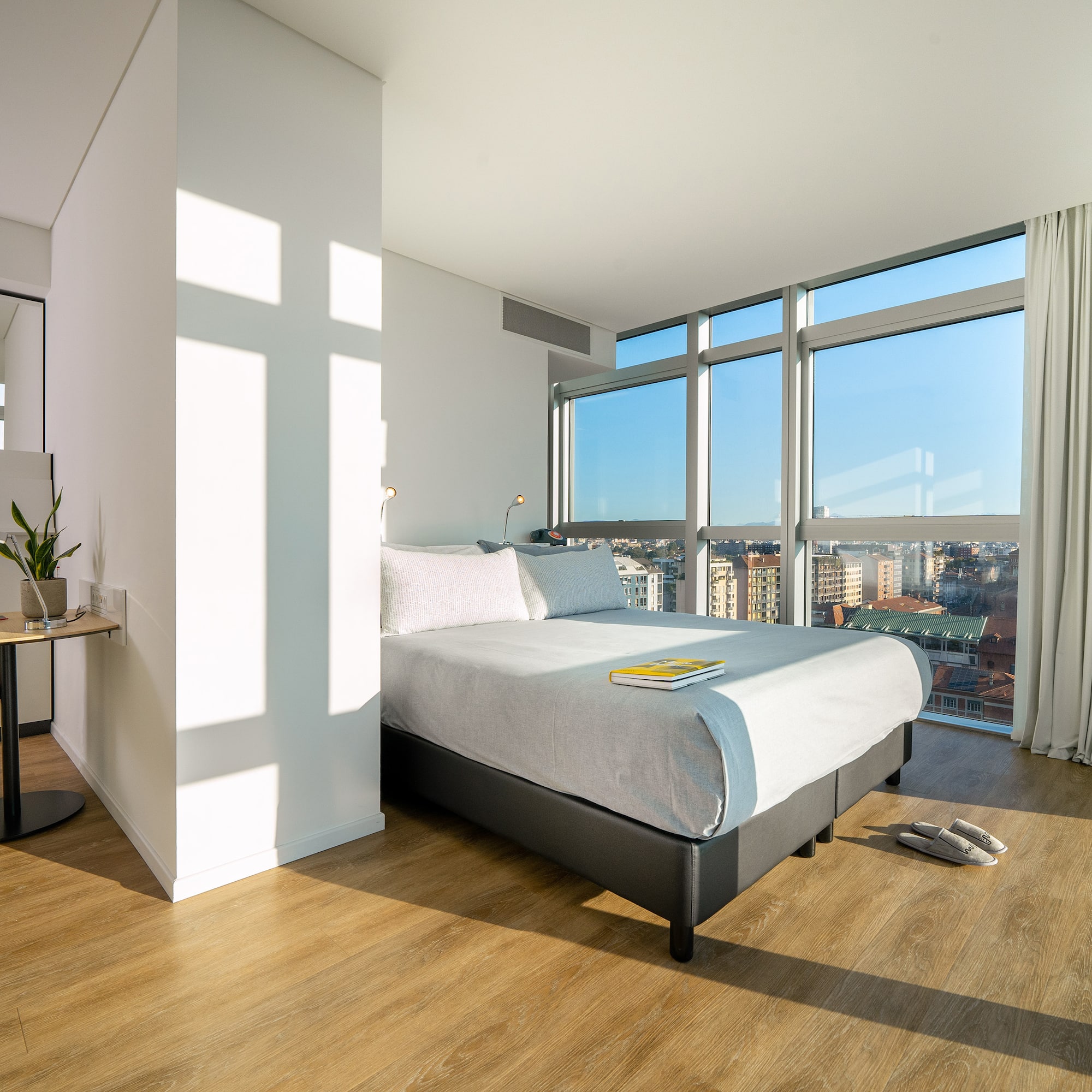 a bedroom with a large window and a bed