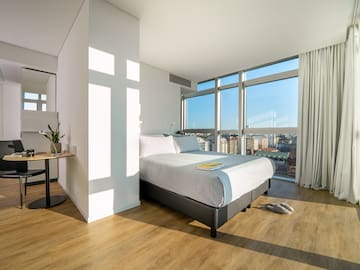 a bedroom with a large window and a bed
