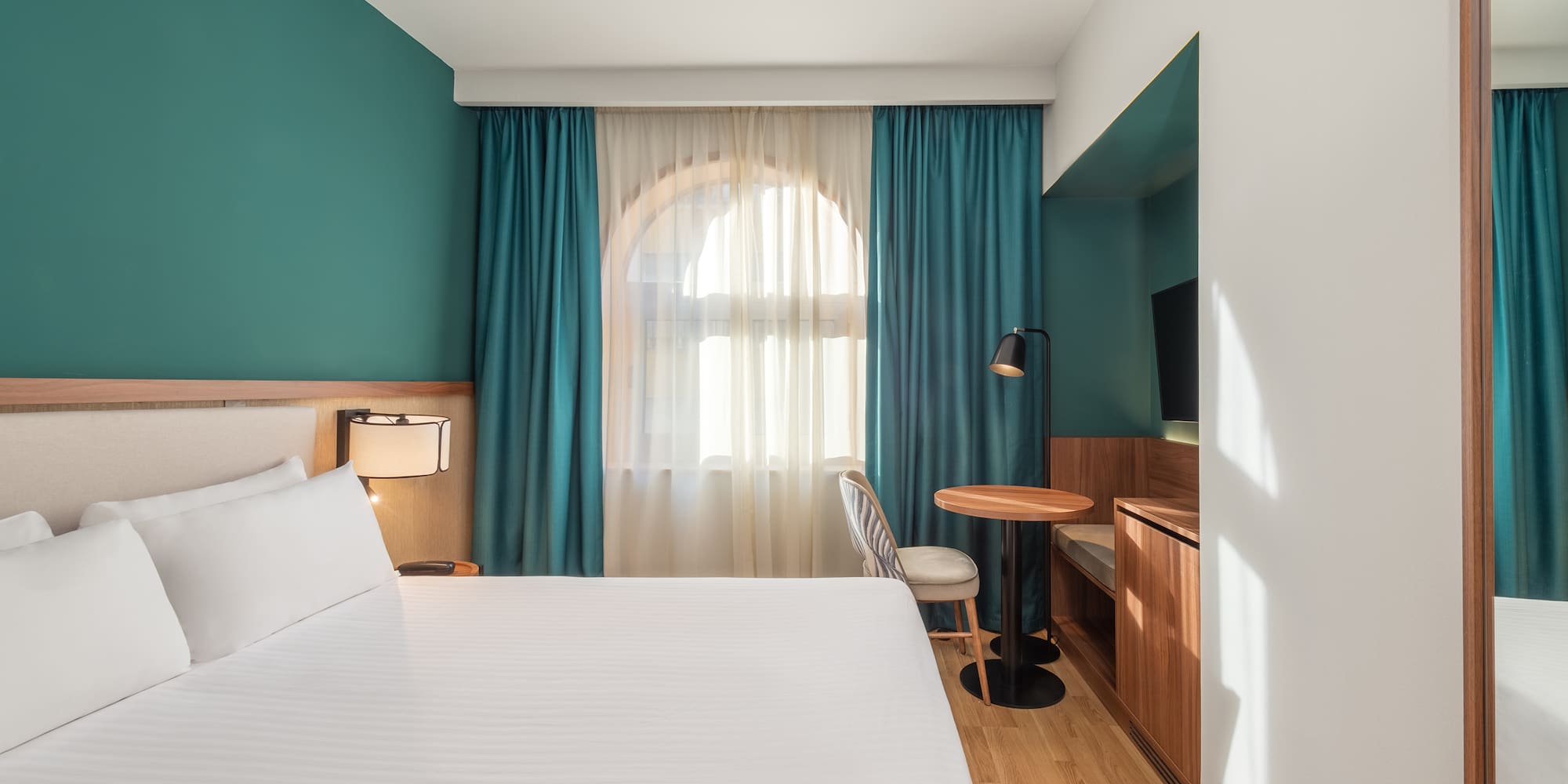 a room with a bed and a table and chair