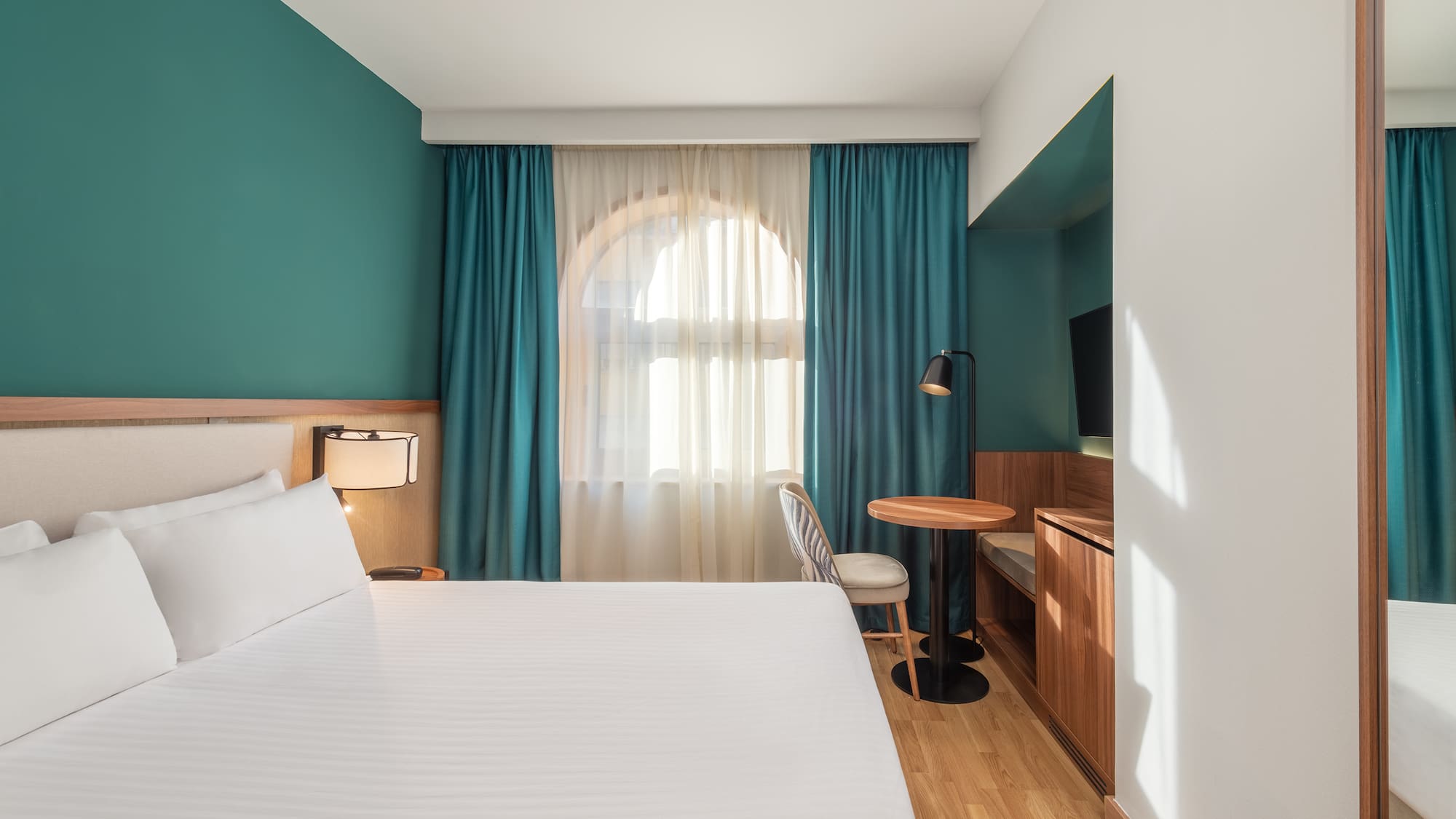 a room with a bed and a table and chair