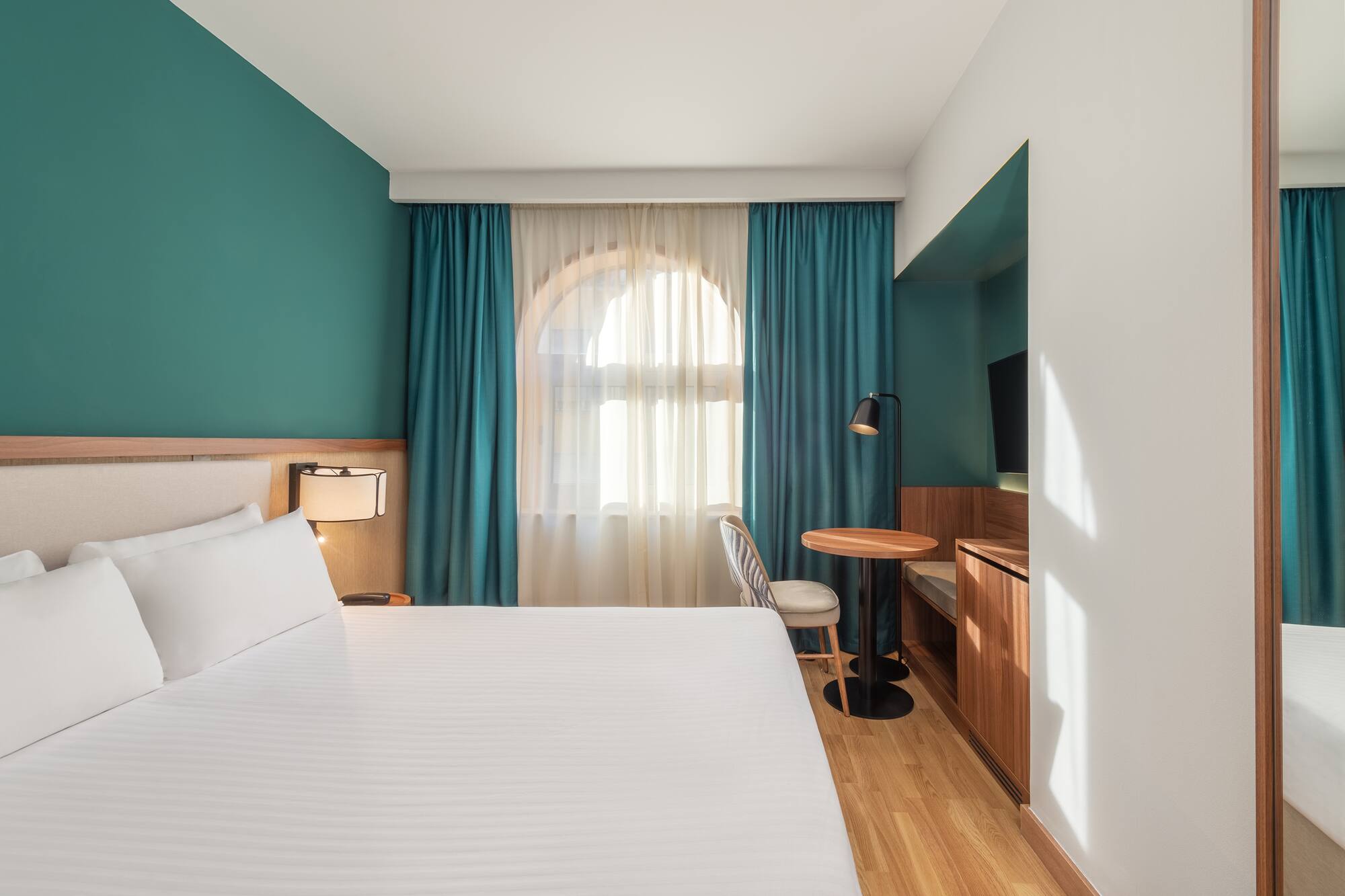 a room with a bed and a table and chair